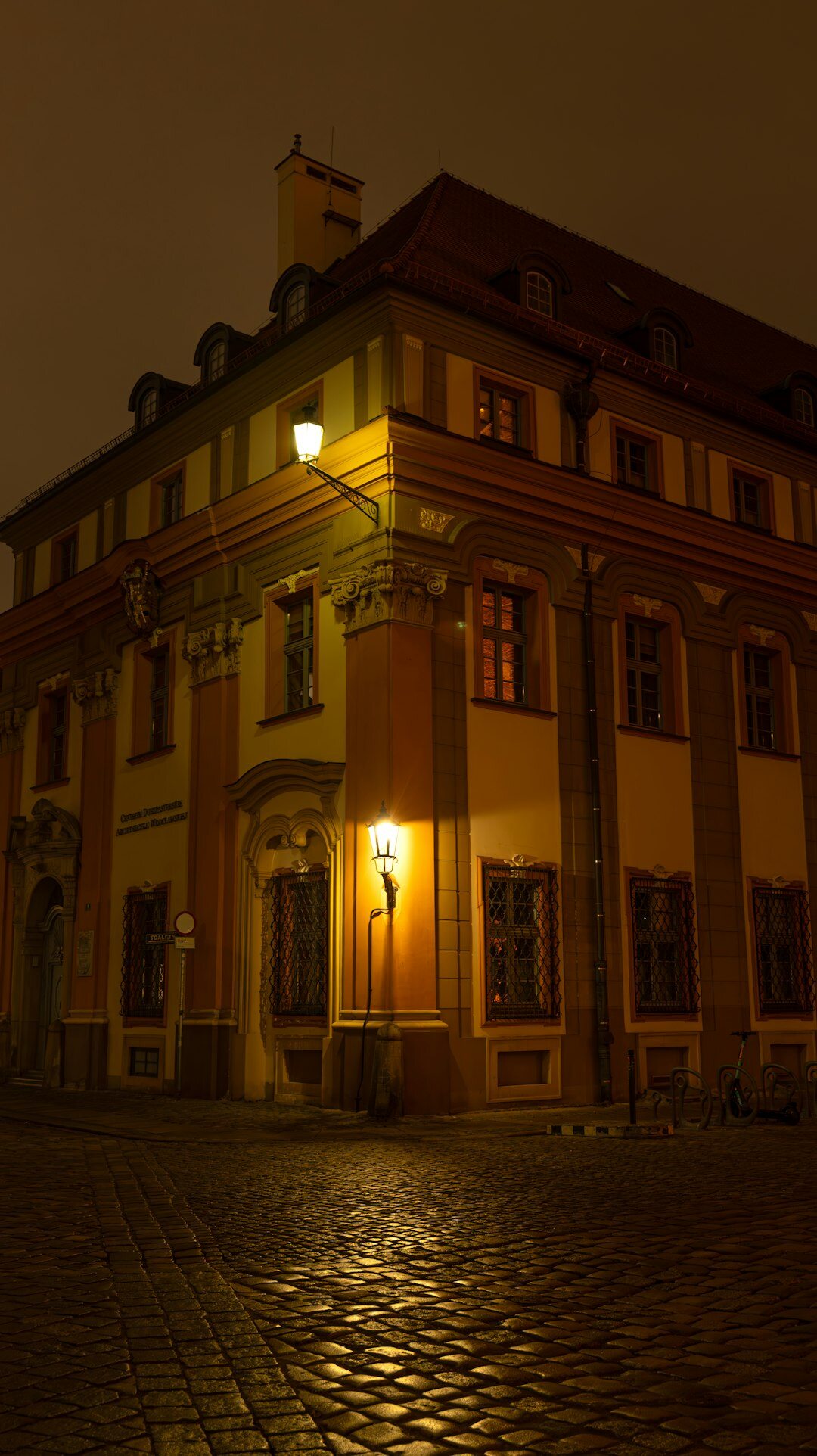 Foggy cobblestone street in old European town at night with gas lamp