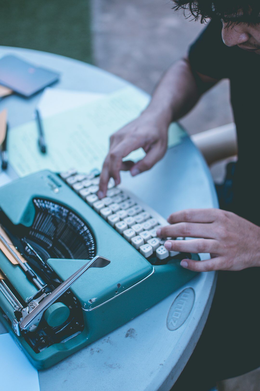 Croatian mystery writer sitting at wooden desk with typewriter in dim study
