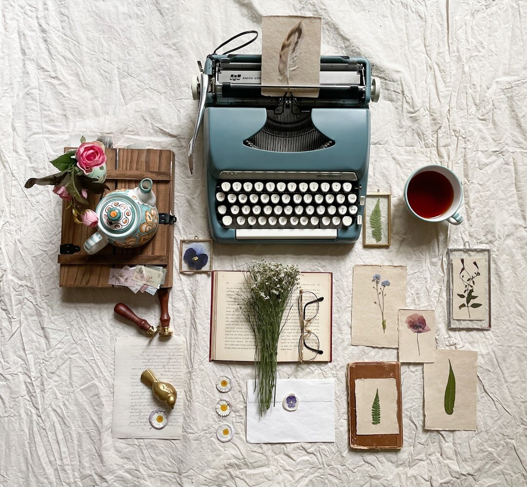 Vintage typewriter with scattered manuscript pages and coffee cup